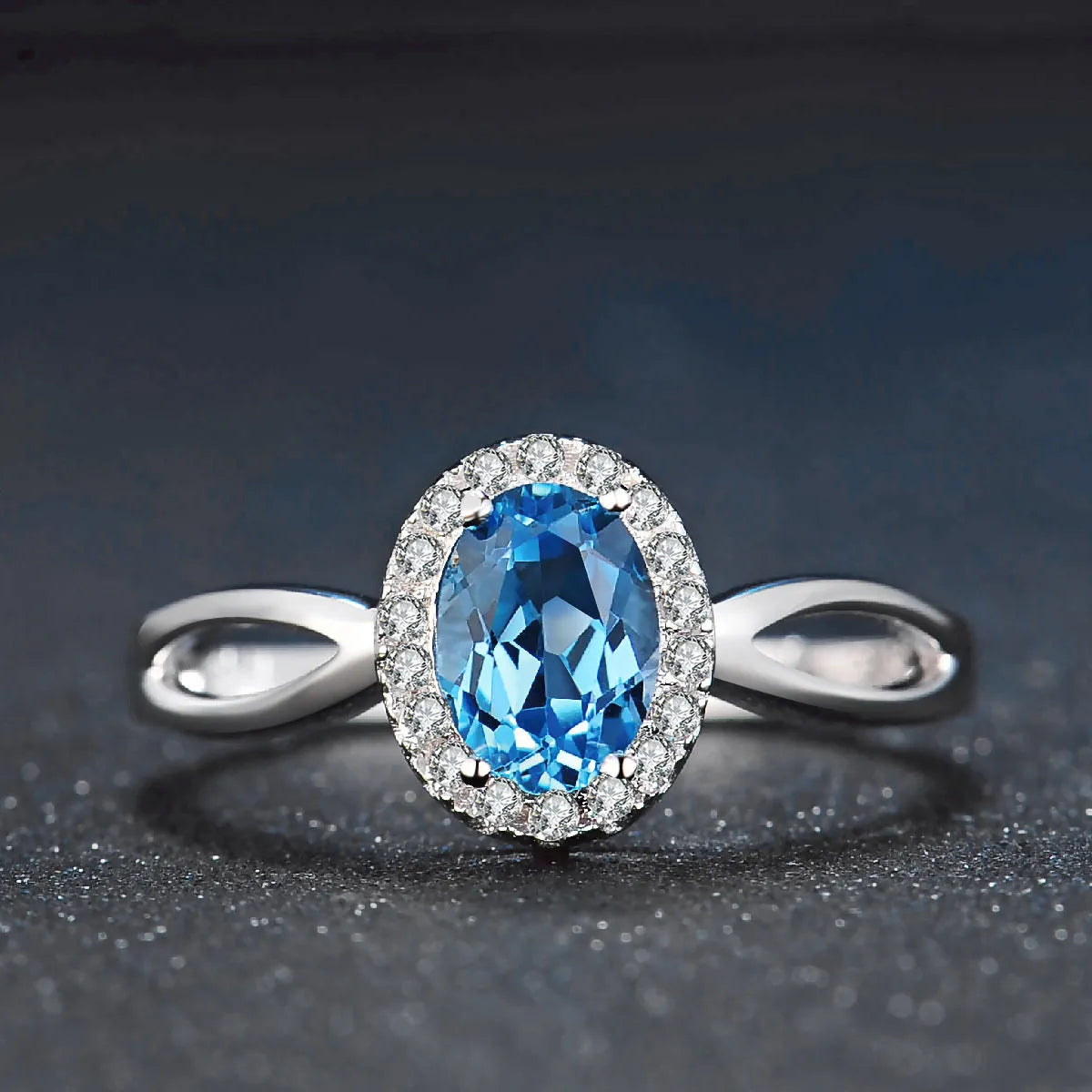 Four-piece sterling silver jewellery set with blue topaz stones: geometric earrings, ring, pendant, and necklace.