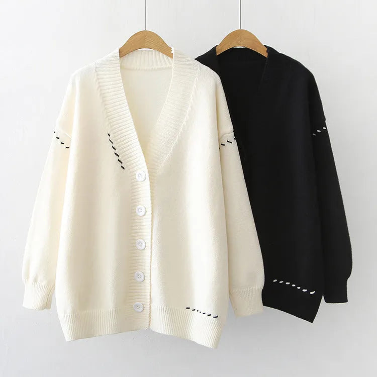 Women's loose black knitted cardigan with long sleeves on hanger