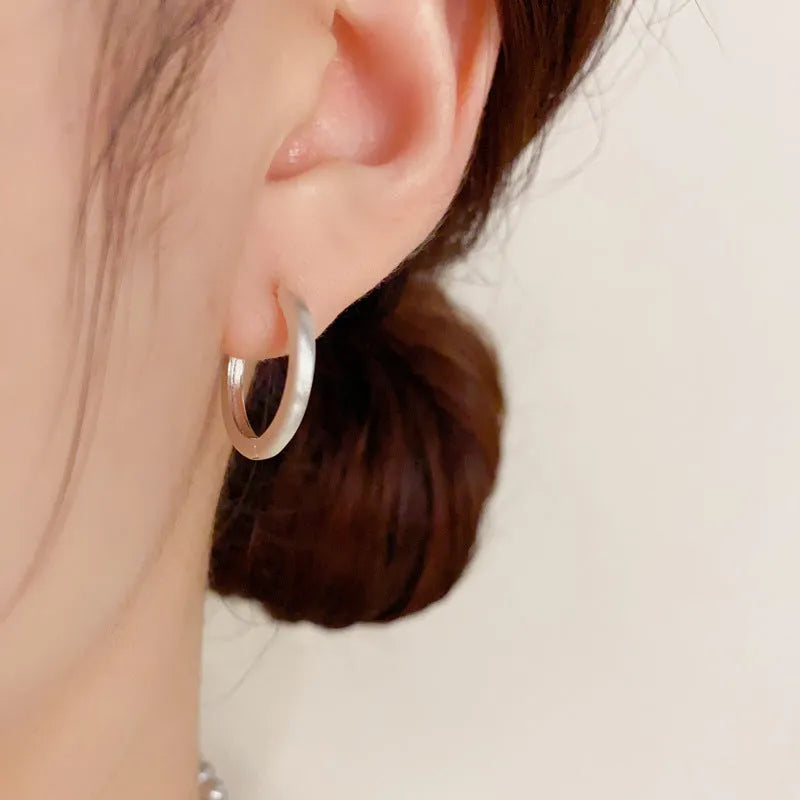Gold and silver geometric round ear clip earrings for women on a simple background.