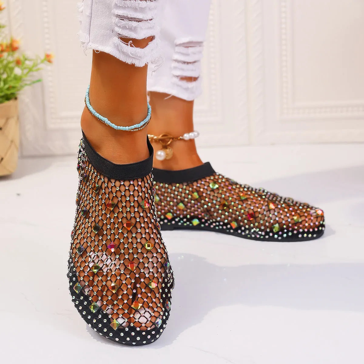 Women's flat sandals with mesh upper, colourful rhinestone detail, and a round toe.