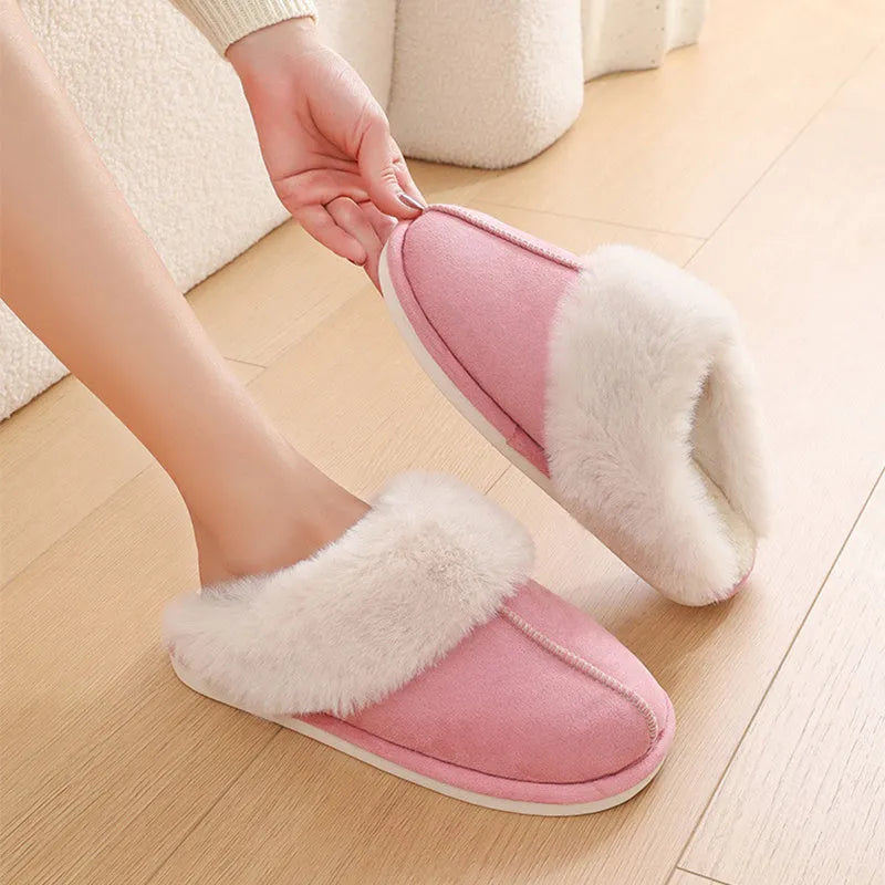 A pair of round-toe flat-heel plush slippers with stitching detail, shown in one of five available colours.