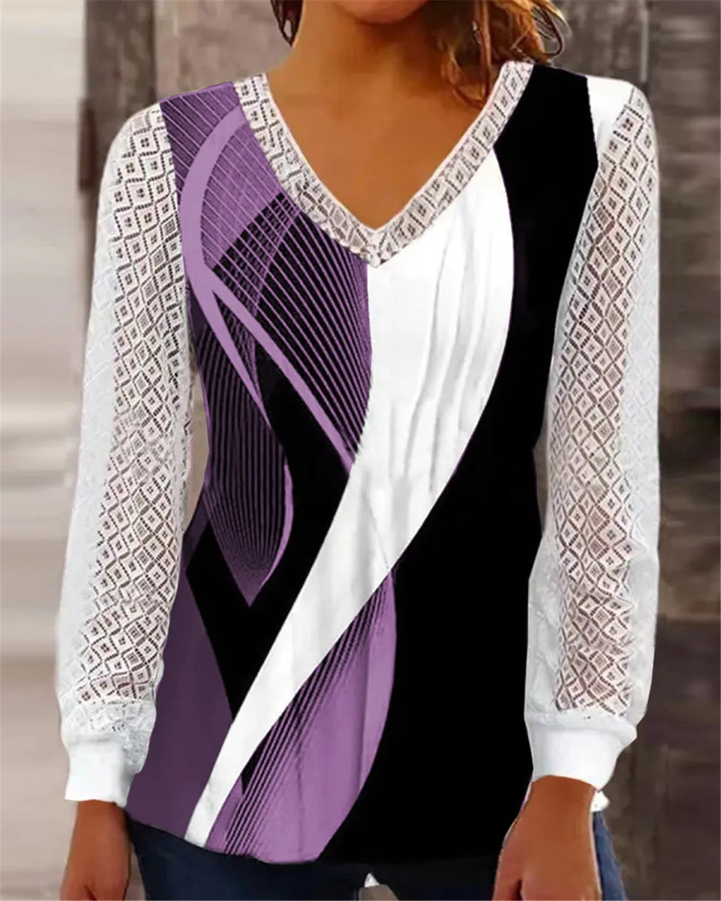 Purple loose fit V-neck lace top with long sleeves and hollow-out detail on a hanger.