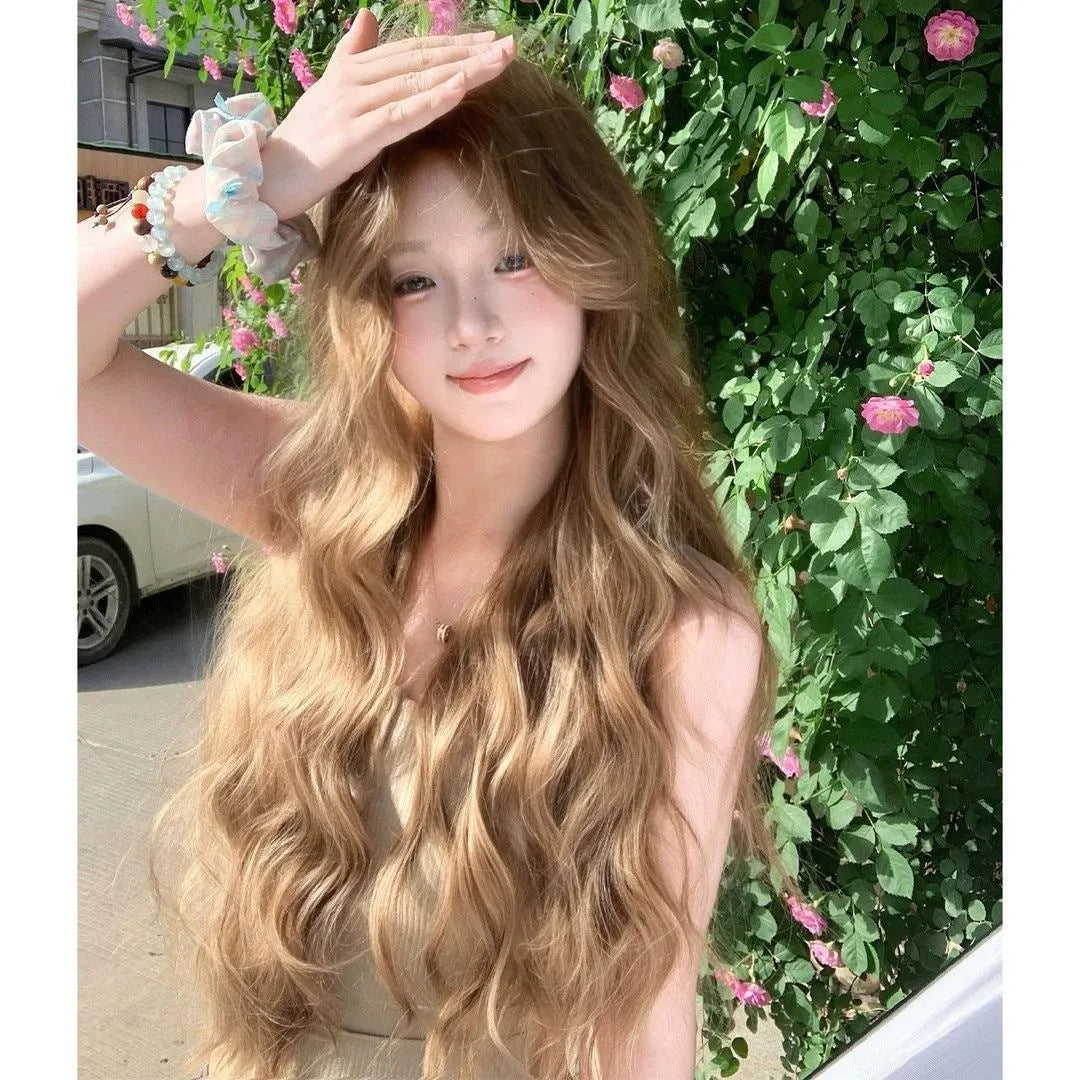 Medium-sized synthetic wig with long curly hair in a linen brown colour, shown with an attached hair net.