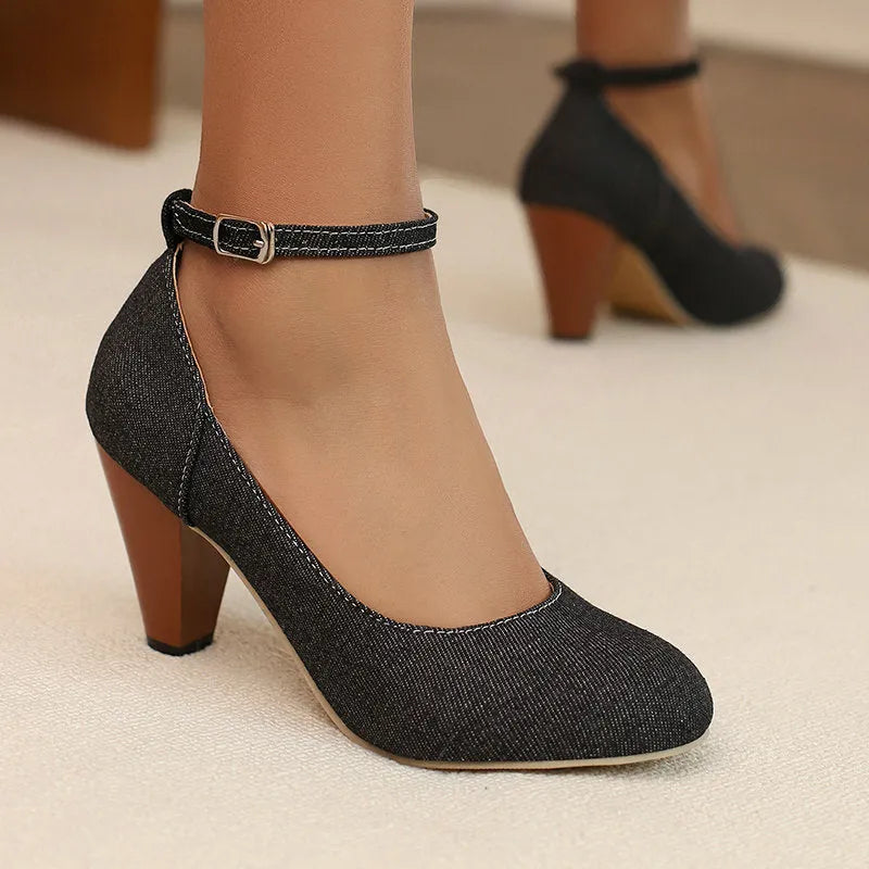 Blue denim women's ankle boots with a buckle strap and thick platform heel on a rubber sole.