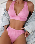 Women's pink halter strap bikini set with split shorts on mannequin display