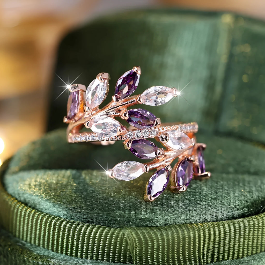 Adjustable copper leaf-shaped ring with zircon gemstone colour options on a white background.
