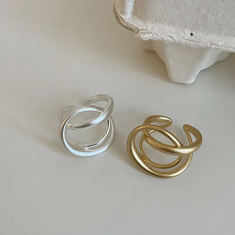 Geometric open ring with three-dimensional interlaced metal and matte electroplated finish in gold or silver colour