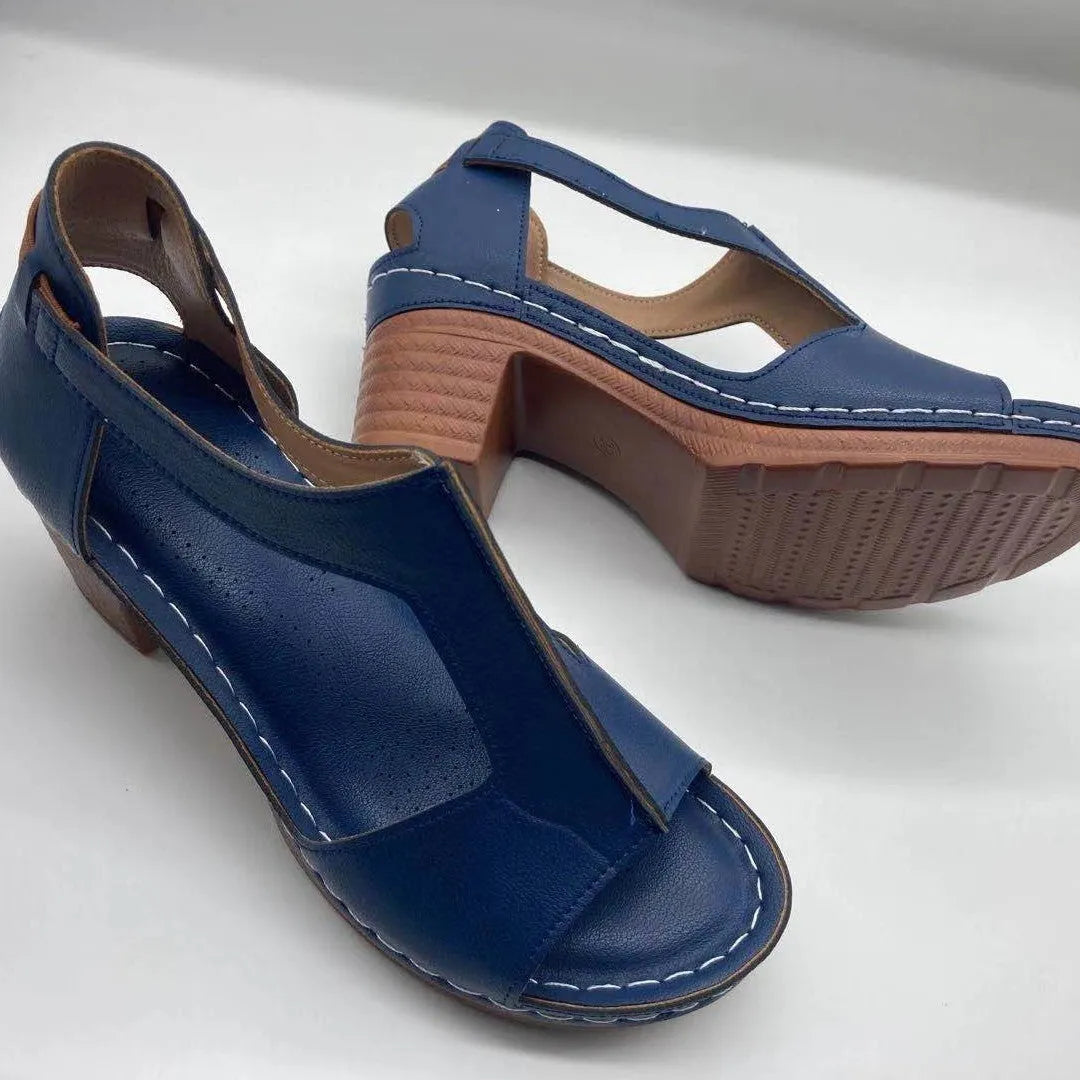 Women's white peep toe wedge sandals with a buckle and low heel on a neutral background.