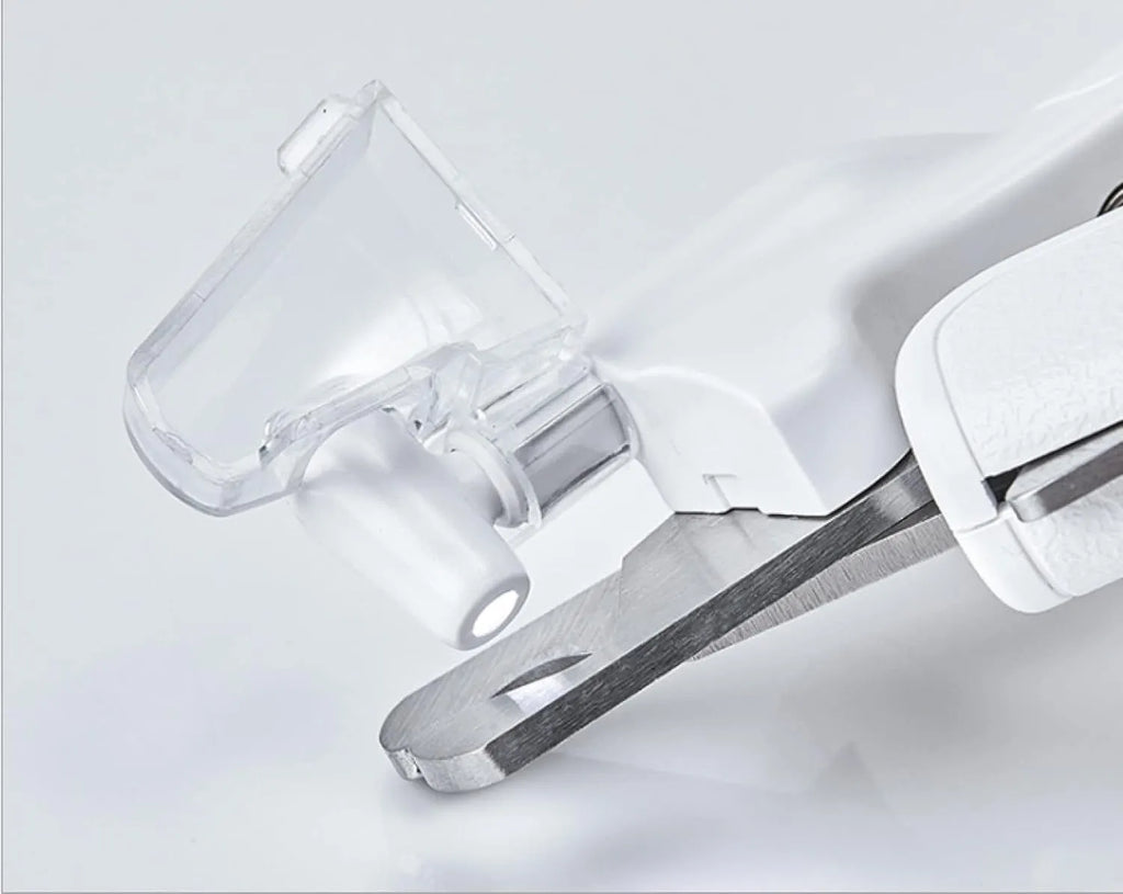 White pet nail clippers with LED light and transparent splash guard open, showing the triangular steel blade.