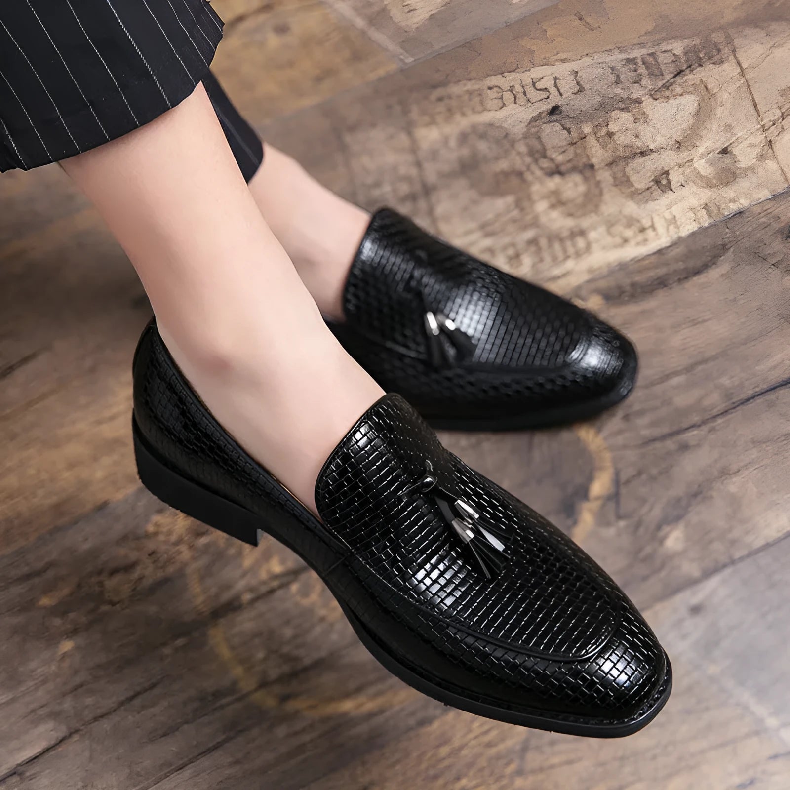 Men's black pointed slip-on shoes with a tassel detail on the front, made from artificial PU.