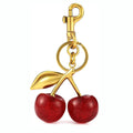 Close-up of a red zinc alloy cherry-shaped pendant key ring on a metal loop.
