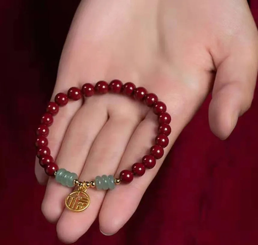 Handmade wave-shaped bracelet in cinnabar and copper beads on a wrist.