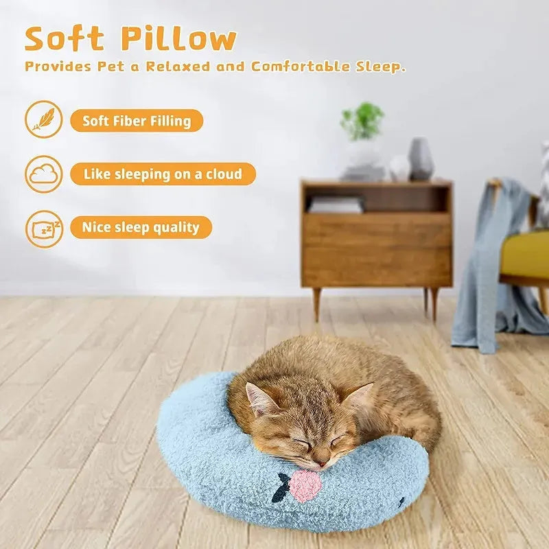 Small white blue yellow U-shaped plush pillow for cats and small dogs on a bed.