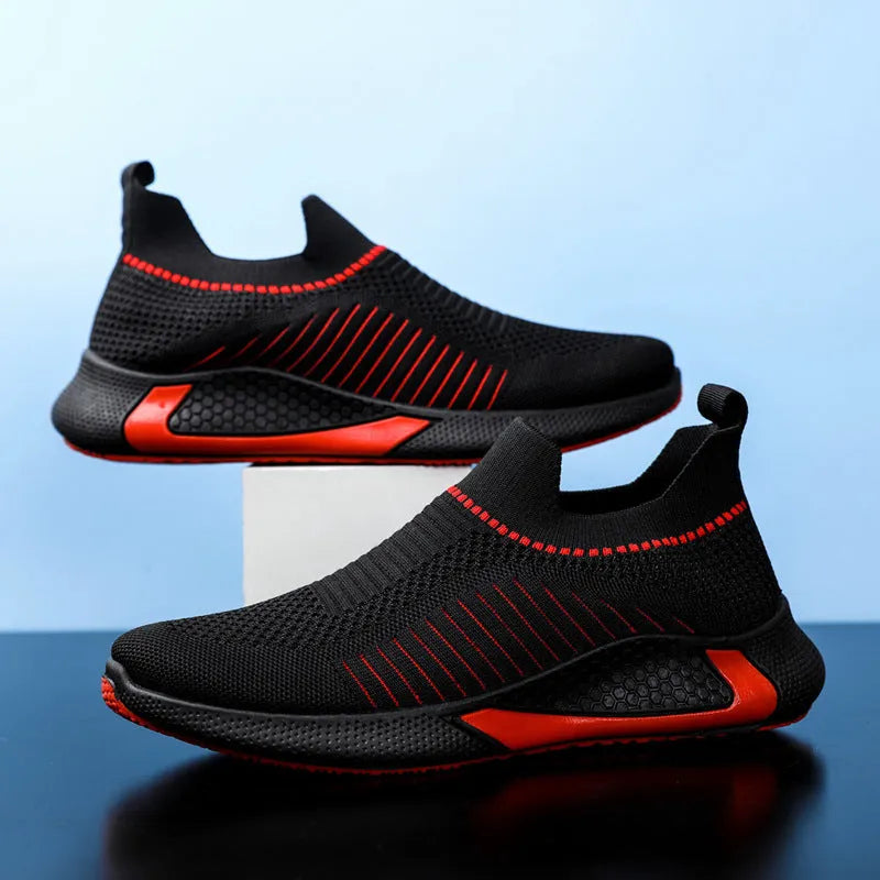 Men's black and white striped mesh slip-on sneakers with lace-up front on a plain background.