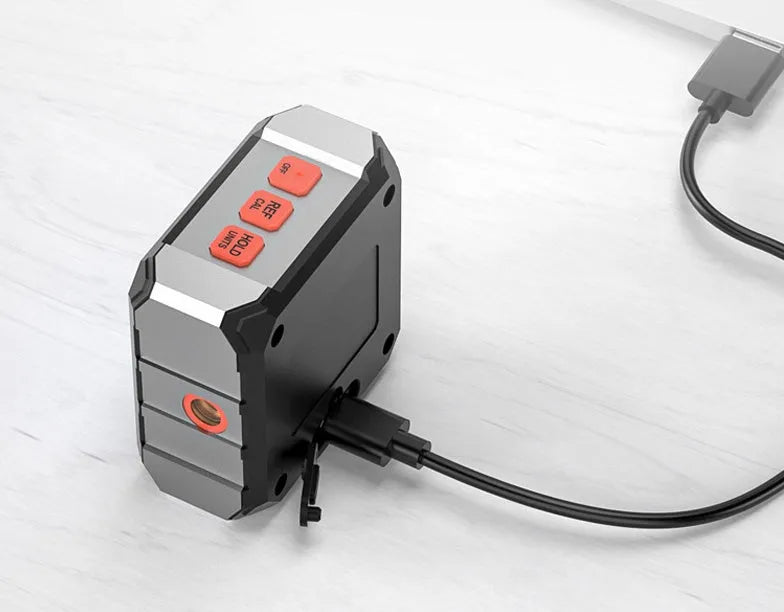 Digital laser inclinometer tape measure with alloy casing and backlit display on a metal surface.