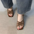 Retro women's sandals with thin cross straps, ankle buckle, and a mid heel in light brown.