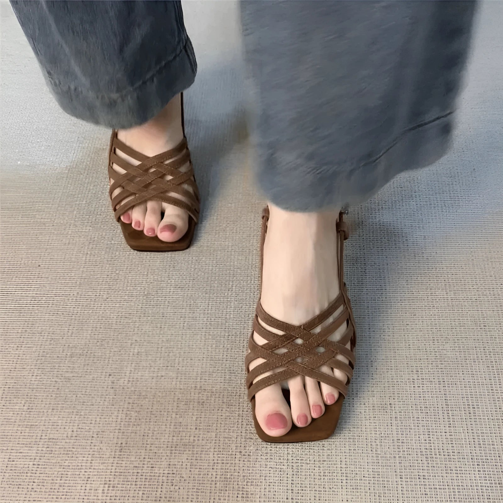 Retro women's sandals with thin cross straps, ankle buckle, and a mid heel in light brown.