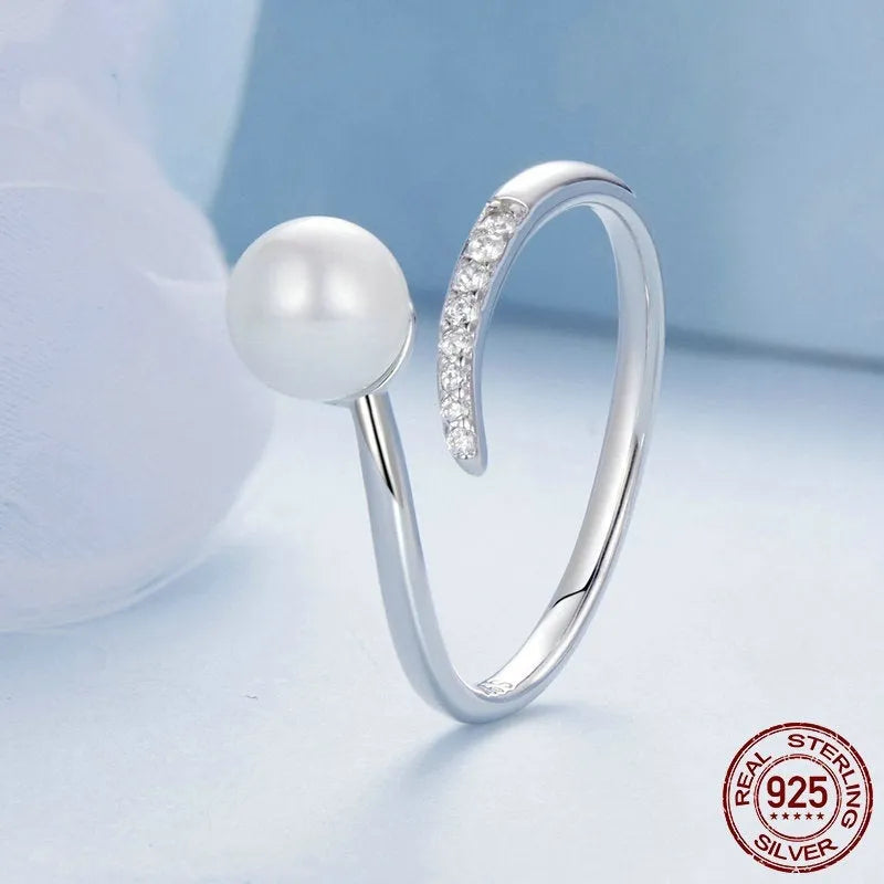 Women's adjustable sterling silver ring with a natural shell pearl on an opening loop band.