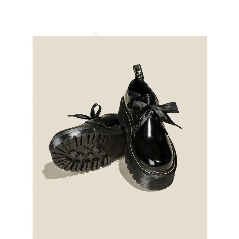 Black and white thick soled women's lace-up shoes with cross straps on a superfine fibre upper.