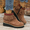Women's dark brown suede wedge ankle boot with side zipper and tassel detail on a thick rubber sole.