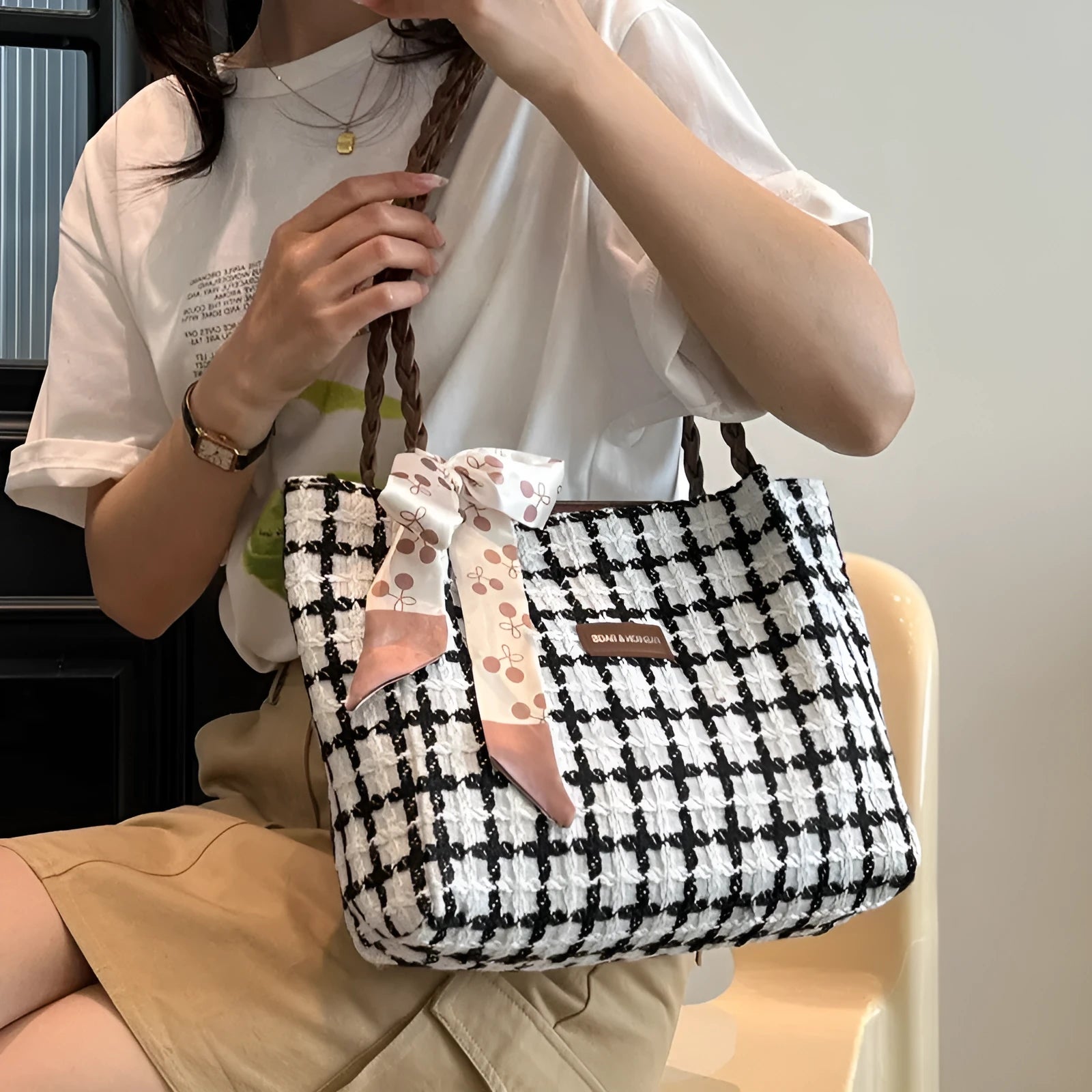 Black woolen shoulder bag with weaving details showing sandwich pocket exterior and interior organisation compartments