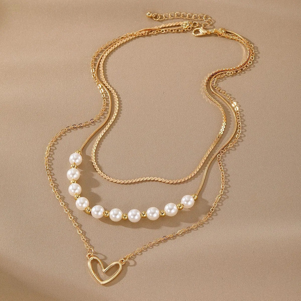 Vintage gold necklace with heart pendant and pearl details on chain
