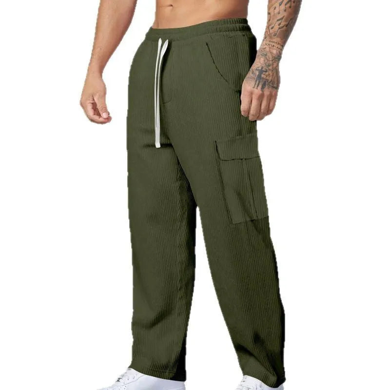 Man wearing navy blue loose-fitting corduroy cargo trousers with a drawstring waist and straight wide legs.