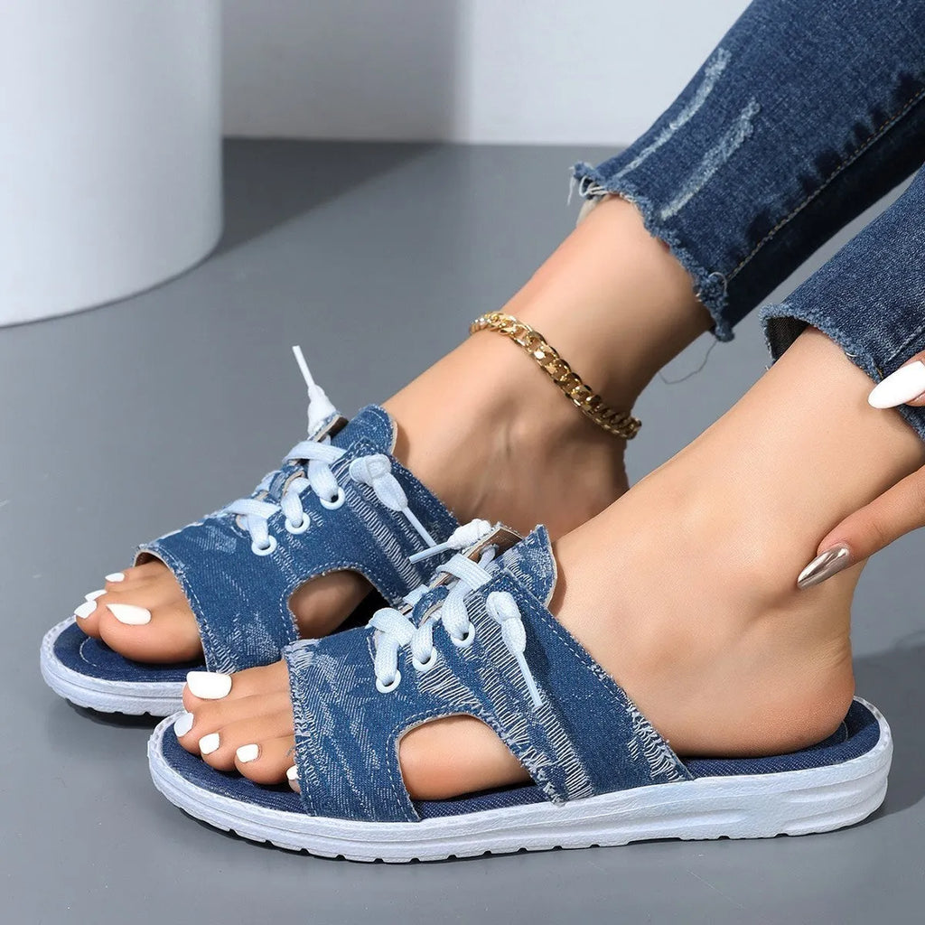 Blue women's flat canvas Roman style slippers with cloth upper and rubber sole.