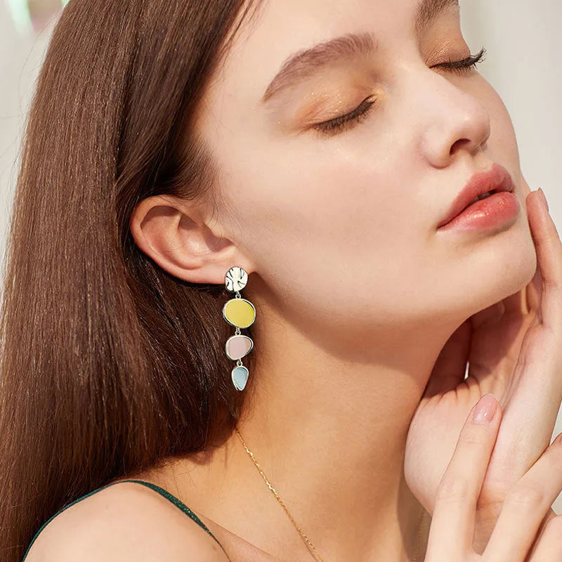 A pair of simple disc-shaped alloy earrings with a blended Morandi three-colour oil drip finish, showing a vintage wafer style.