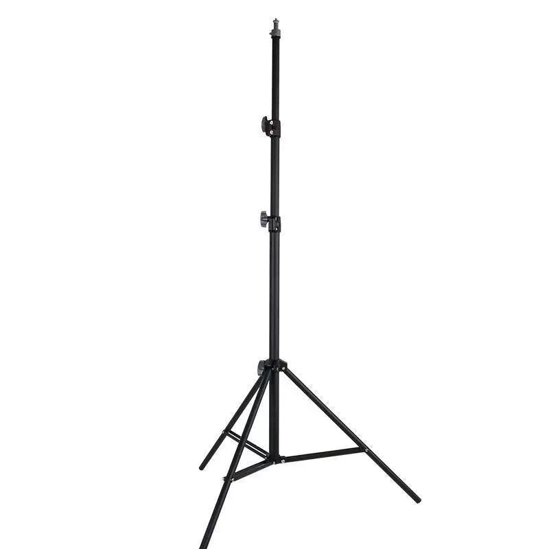 Tall black floor tripod stand holding a mobile phone extended to its full height on a wooden floor.