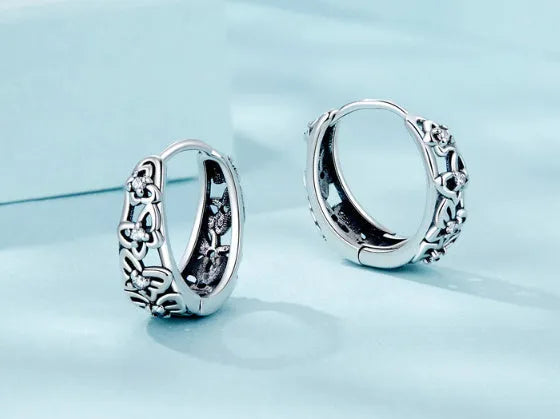 Sterling silver retro hollow butterfly earrings with zircon accents on a white background.