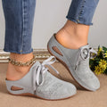 Women's black lace-up wedge slippers with suede upper and hollow-out design on a rubber sole.