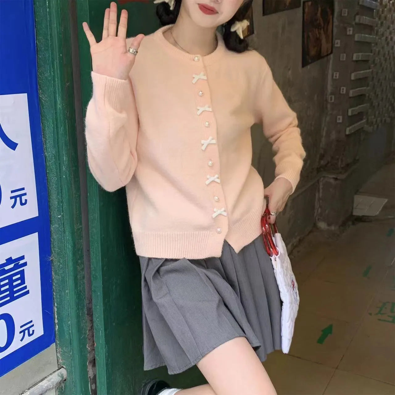 Women's cashmere blend cardigan sweater with pearl buttons and bow detail in solid colour