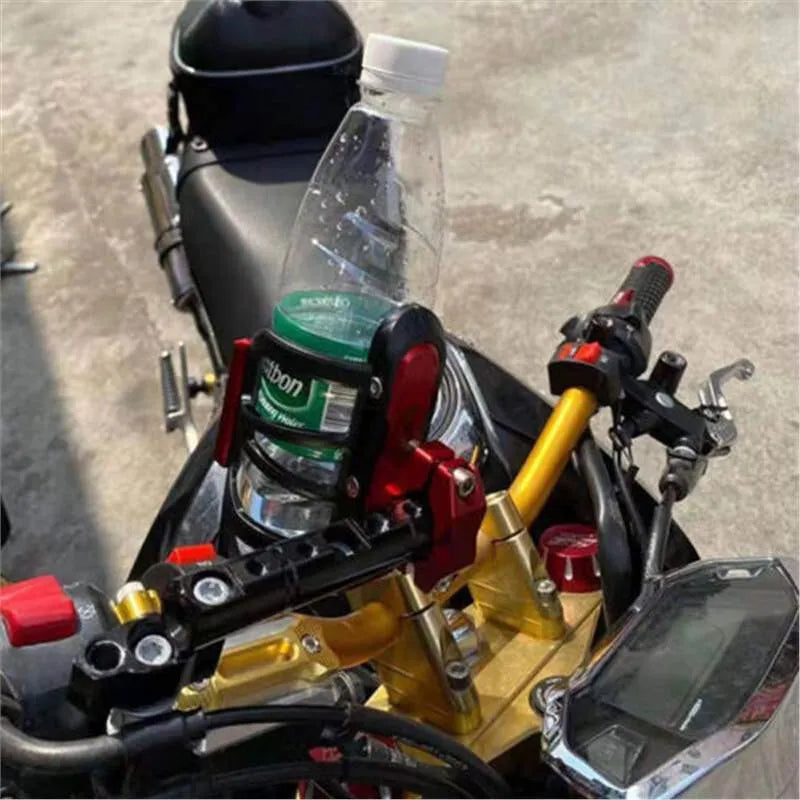 Black modified water bottle cage mounted on a Honda X-ADV scooter bumper for drink storage.