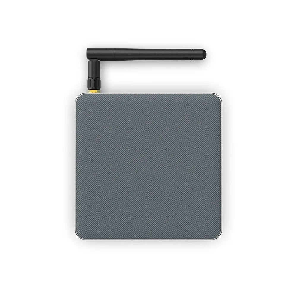 Black Android 8K set-top box with remote control, HDMI cable, and UK plug on a wooden surface.