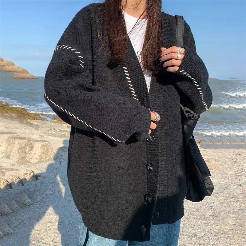 Women's loose black knitted cardigan with long sleeves on hanger