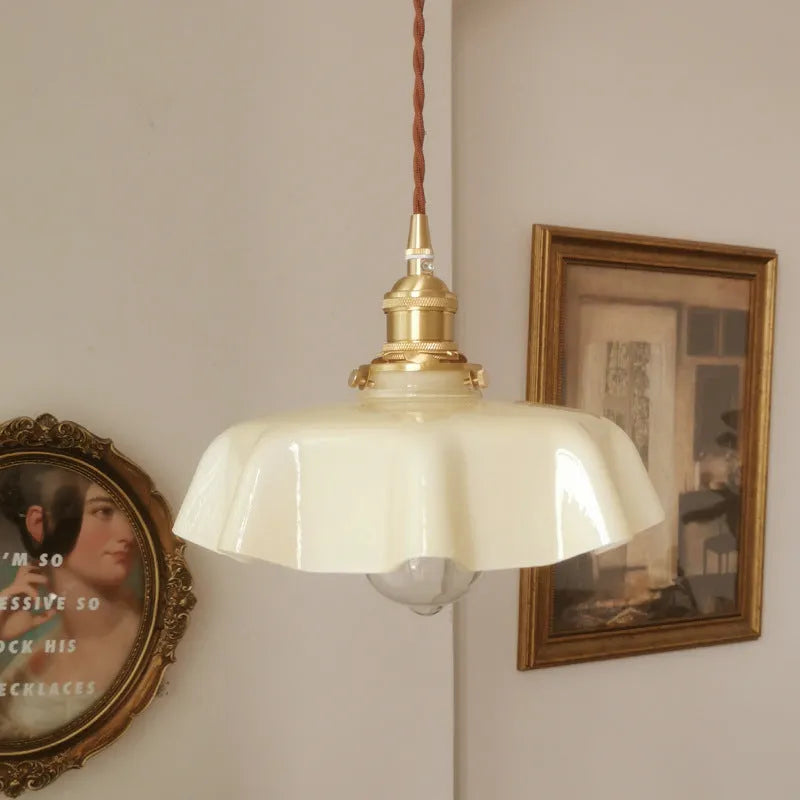 Medieval brass flower bud design glass chandelier hanging from a ceiling, shown in a light blue colour variant.