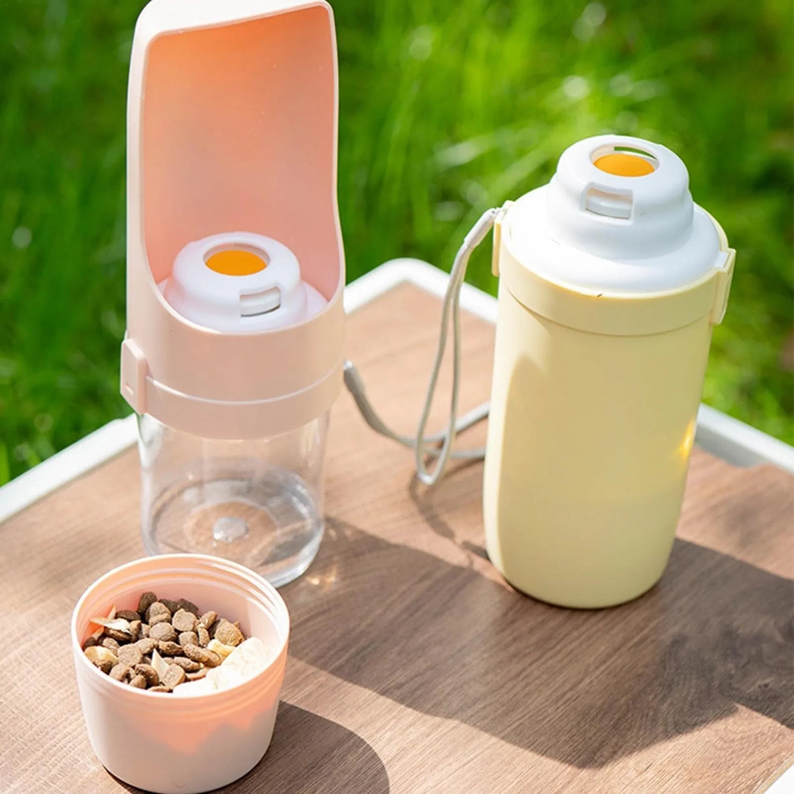 Green portable pet water bottle and food feeder with attached lanyard, showing transparent cup design.