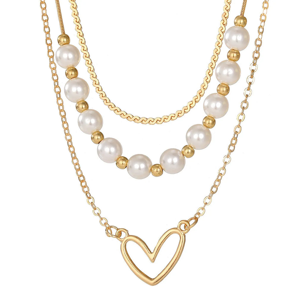 Vintage gold necklace with heart pendant and pearl details on chain