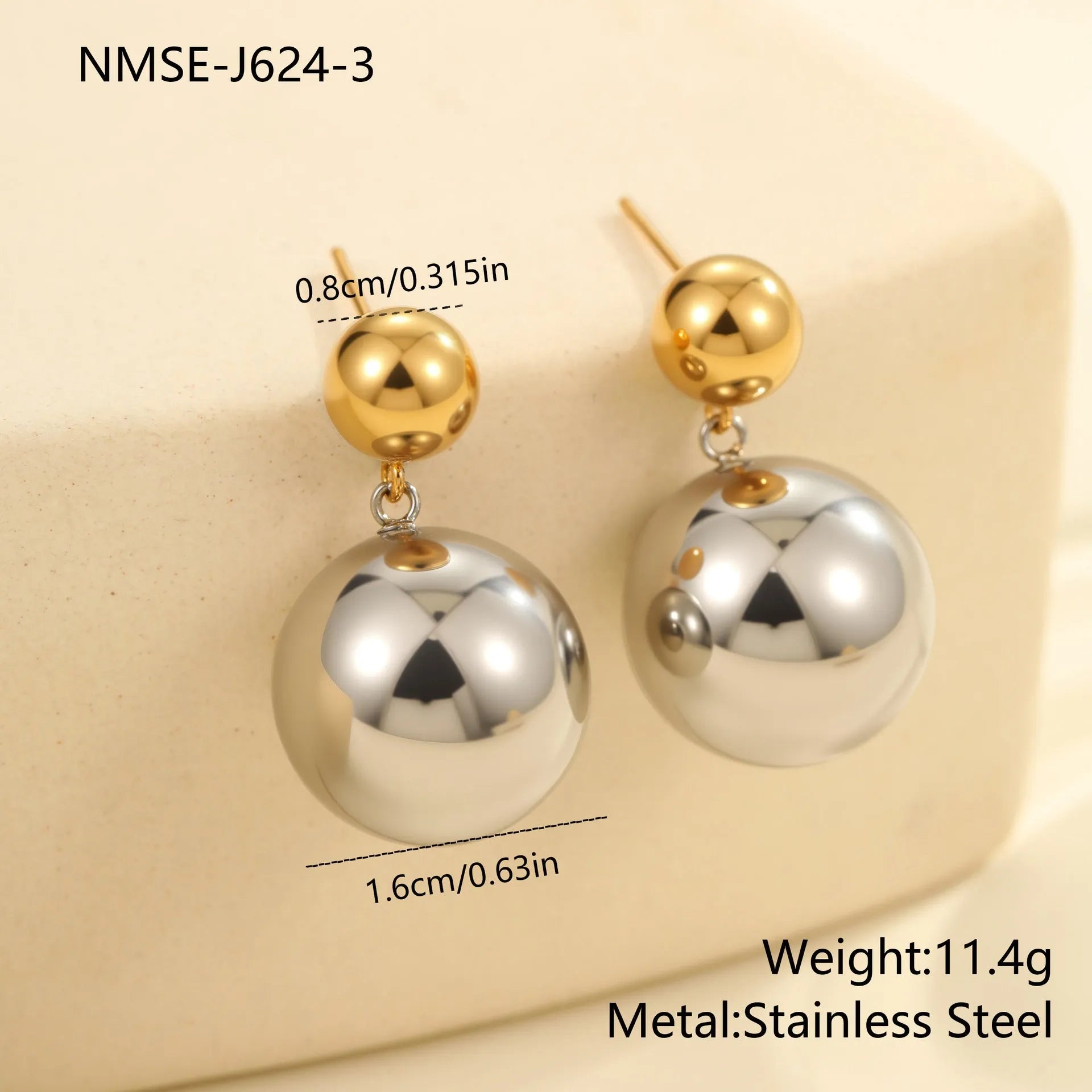 Pair of round bead stud earrings with gold plating and colour-block design on a woman's earlobe.