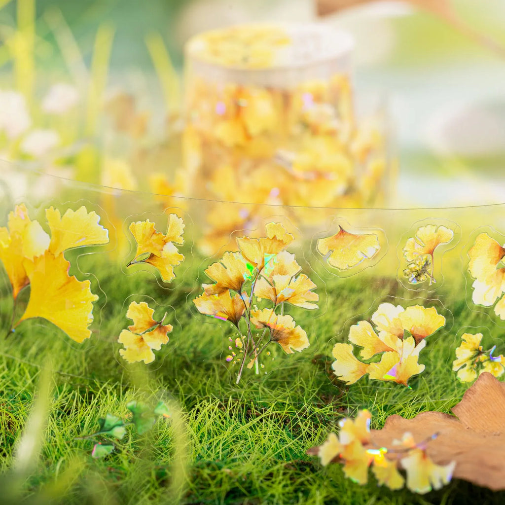 Roll of nature-themed decorative stickers showing ginkgo leaves, maple leaves, and blue fallen leaves designs