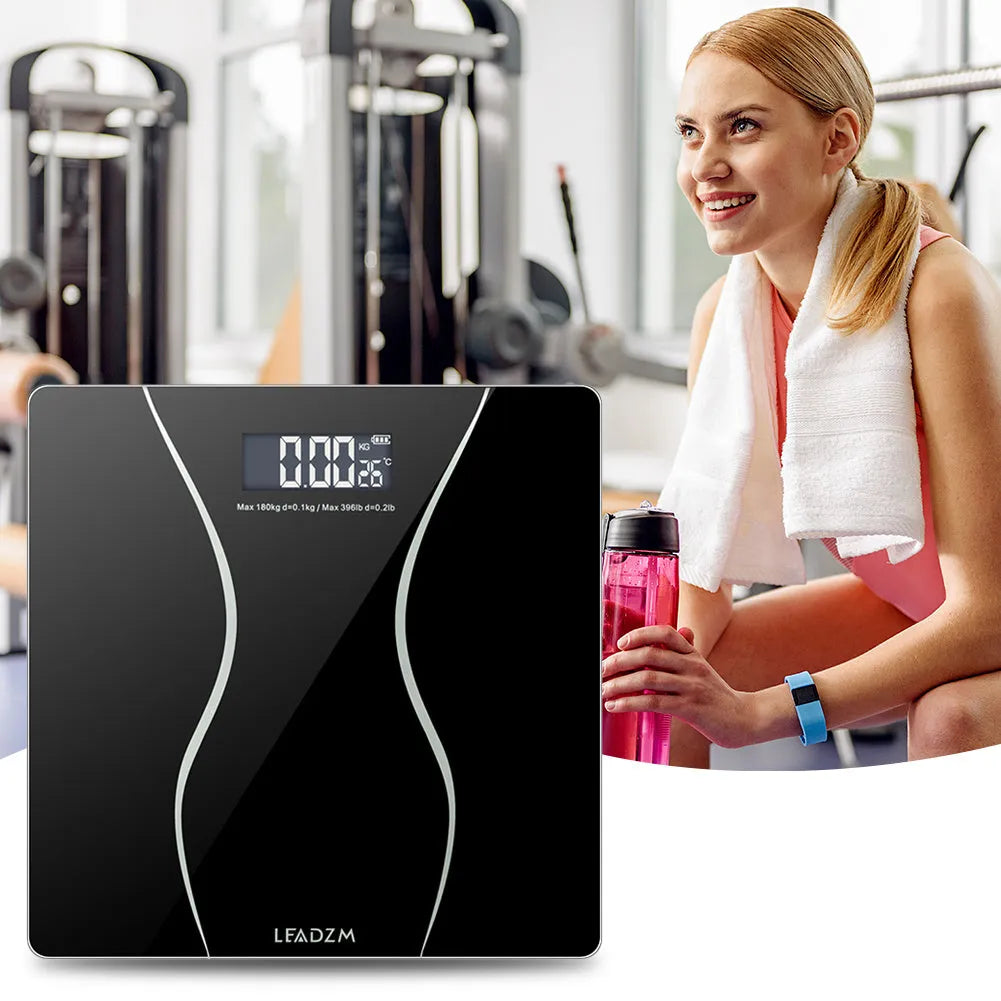 Black electronic digital bathroom scale with a digital display, shown on a bathroom floor.