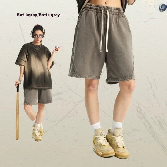 Man wearing retro-style batik washed grey-green cotton terry shorts with a loose fit.