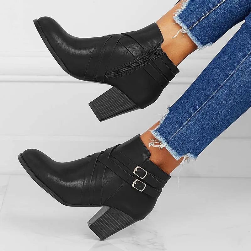 Grey PU leather short ankle boot with a 7cm chunky heel, side zip, and belt buckle on a wooden background.