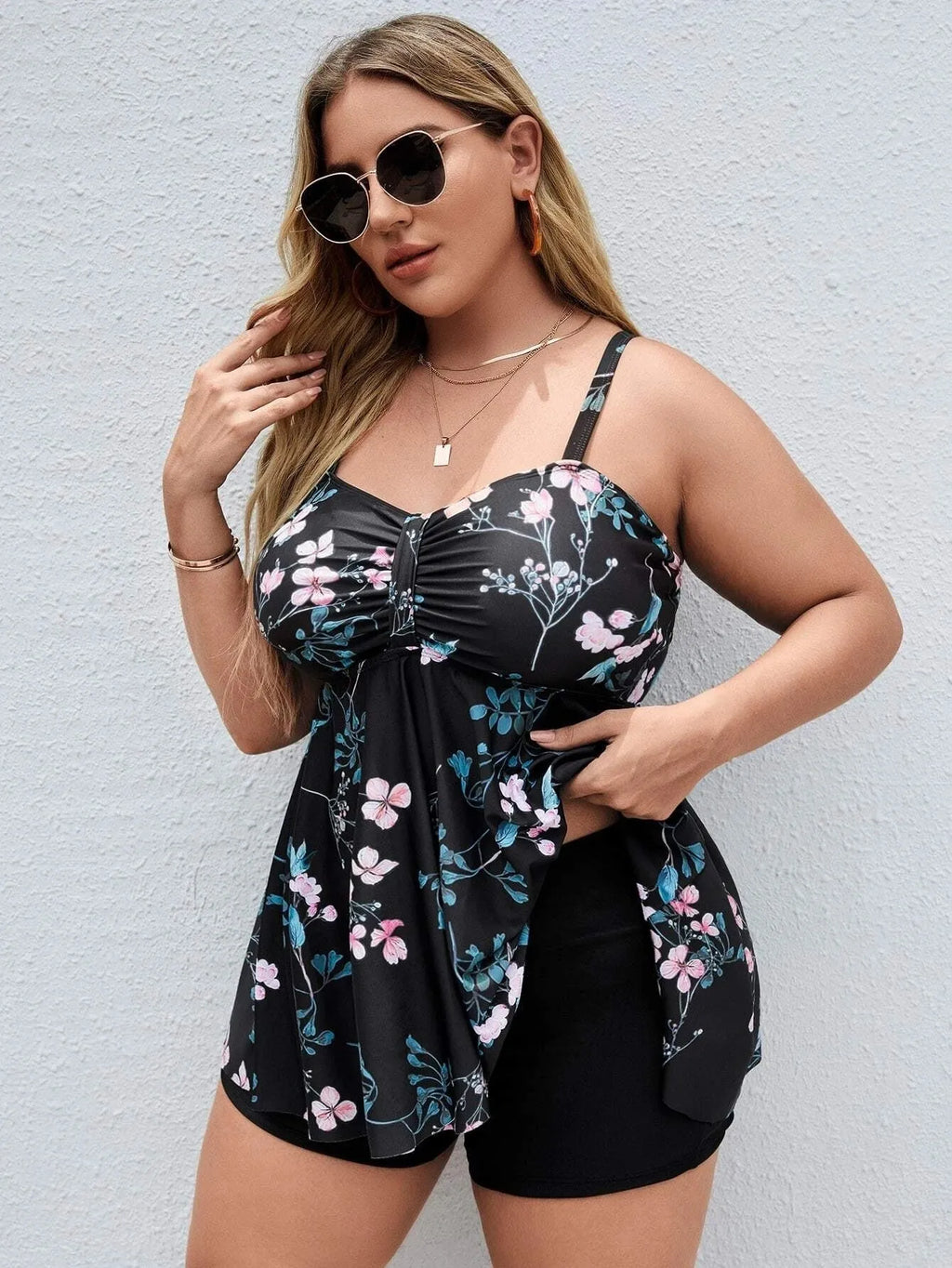Women's floral print one-piece swimsuit on a hanger, showing split colour design and stretchy polyester fabric for plus sizes.