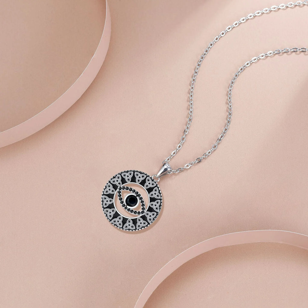 Close-up of a copper Devil's Eye pendant necklace on a cross chain for women.