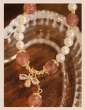 Women's handmade strawberry quartz crystal bracelet with stringed pearls and bow decoration