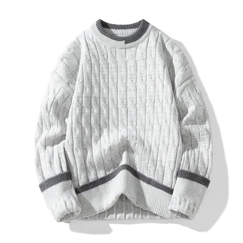 Man wearing a loose grey and white patterned long-sleeve pullover sweater.