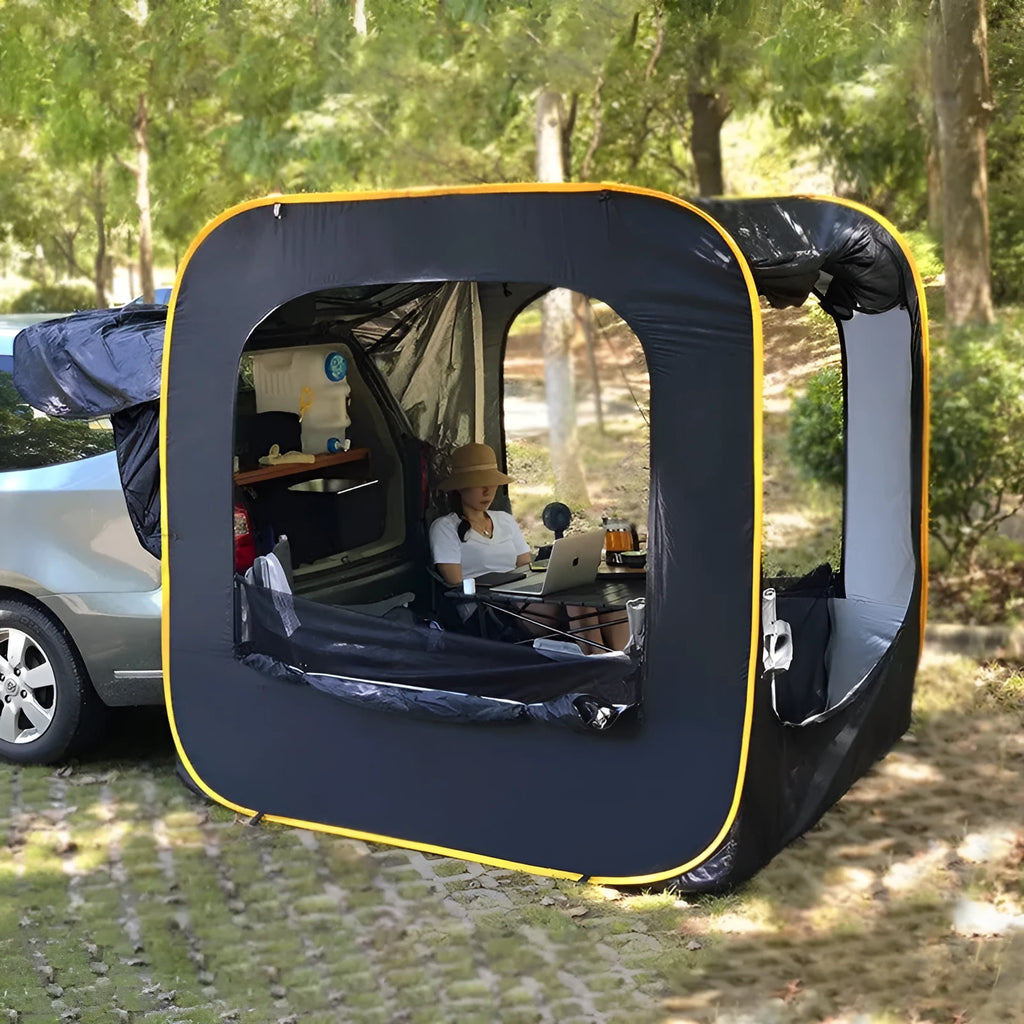 Black pop-up car tailgate camping tent unfolded next to a vehicle