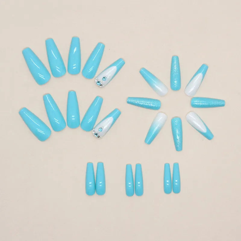 Long ballet false nails with smart blue diamond accents on solid colour background